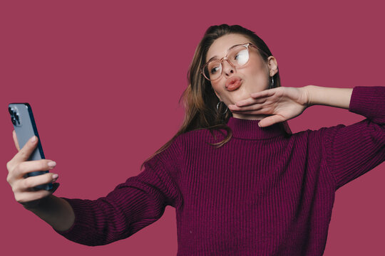 casual shot of woman with glasses and phone, authentic social media clip of woman smiling naturally