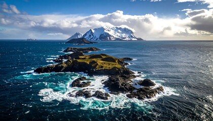 Aerial view showcases a rugged coastal landscape with a cluster of rocky islands in deep blue waters under a cloudy sky. A snowy mountain is in the distance