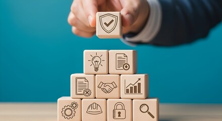 Hand stacking wooden blocks with icons representing business strategy, security, and innovation, symbolizing growth and protection