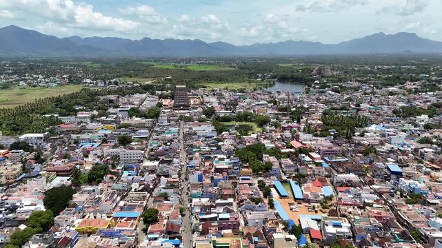 Aerial view of Tenkasi town in Tamil Nadu featuring the grand Kasi Viswanathar Temple, serene pond, and distant Western Ghats mountains under a bright tropical sky.