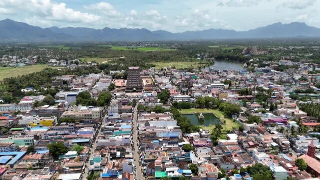 Vibrant aerial video of Tenkasi, Tamil Nadu, showcasing the towering temple gopuram, Temple Pond, lush greenery, and majestic Western Ghats beyond.