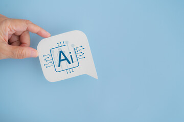 Hand hold real white speech bubble paper cut with Ai icon on blue background