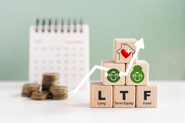 For LTF, elderly saving, healthy grandparents, wellness, wellbeing, retirement, pension concept. Old persons, home with heart icon, text on wooden cube blocks, blurred coins and calendar