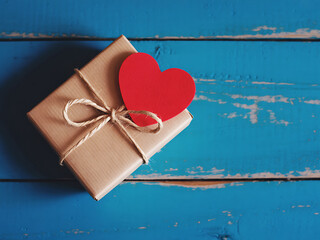 Kraft Paper Wrapped Gift Tied with Twine on Blue Wooden Surface