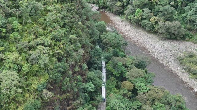 Following the railway line running alongside the Urubamba River bank through lush jungle as it travels toward Aguas Calientes (Machu Picchu Pueblo) station