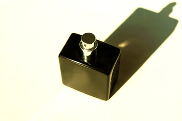 Minimal Black Perfume Bottle with Strong Shadow in Golden Light