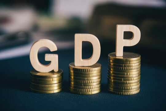 Three stacks of golden coins, each topped with a wooden letter G D P, are arranged on a dark surface