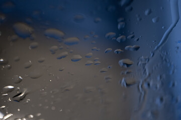 Water droplets on glass surface with soft blue light