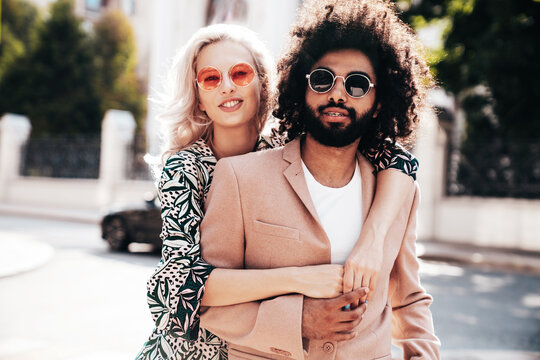 Beautiful fashion woman and her handsome elegant boyfriend in beige suit. Sexy blond model in summer suit clothes. Fashionable smiling couple posing in street Europe. Brutal man and female outdoors