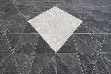 Black granite tiles floor with white kite shaped perspective pattern background