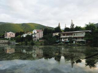 Obraz premium Landscape with a small mountain pond with houses among hills