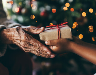 A grandmother's hands giving a gift to a grandchild