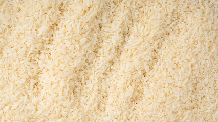 Grated coconut powder. Dry coco flakes pile, shredded desiccated coconut, tropical fruit chips