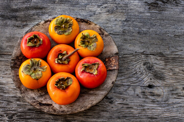 Ripe persimmon fruits in the wooden bowl. Trabzon or cennet hurması 