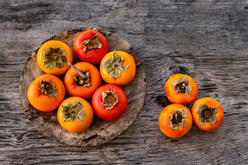 Ripe persimmon fruits in the wooden bowl. Trabzon or cennet hurması 