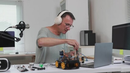 Male vlogger assembling a robotic car during livestreaming