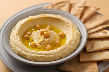 Creamy hummus with pita bread and olive oil drizzle