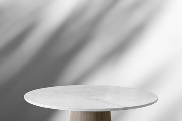 Round marble table top with tree leaves shadow drop on white wall background for mockup product display