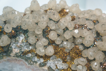 Close-up of calcite crystals perched on chalcopyrite matrix, highlighting contrast of golden metal...
