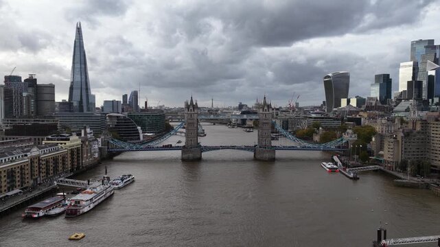 Tower bridge in London, The United Kingdom. Monumental iconic bridge over the thames river. Aerial drone video on cloudy day.