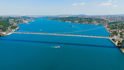 Istanbul, Turkey. Bosphorus bridge aerial view with maritime traffic and cargo ships passing under...