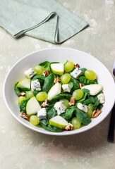 Salad with spinach, blue cheese, pear, grapes, and nuts. Healthy eating. Vegetarian.