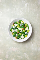 Salad with spinach, blue cheese, pear, grapes, and nuts. Healthy eating. Vegetarian.