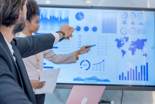 group business meeting in conference room looking screen displaying graphs charts. Business professionals analyzing discussing data corporate presentation Charts graphs statistics in modern office