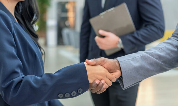 handshake diverse group teamwork meeting business professionals in suits shaking hands trust contract in an office. symbolizing agreement partnership success professional networking. - Powered by Adobe