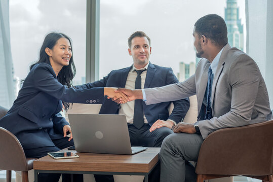 handshake diverse group teamwork meeting business professionals in suits shaking hands trust contract in an office. symbolizing agreement partnership success professional networking.