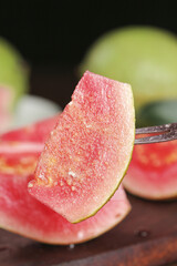 Fresh Red Guava Fruit Slices with Pink Flesh and Seeds on Wooden Background