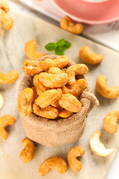 Crispy Fried Vietnamese Cashew Nuts in Rustic Burlap Sack on Wood Background