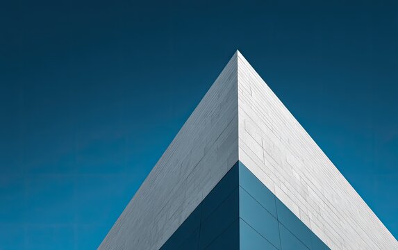 Architectural detail of a building with triangular corner against clear blue sky
