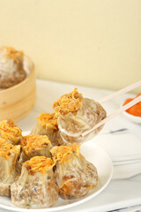 Handmade Siu Mai Dim Sum Dumplings with Salted Egg Yolk and Meat Filling on White Plate
