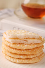 Crispy Rice Cakes Snacks Stacked on Table with Tea Cup Background