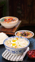 Traditional Handmade Ramen Noodle Bowls with Soft Boiled Eggs and Asian Toppings on Rustic Wooden Background