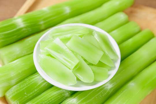 Fresh Green Celery Stalks and Chopped Pieces in Bowl on Wooden Background