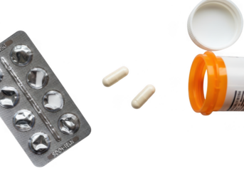 A blister pack of pills and two loose capsules next to an open prescription bottle, isolated on transparent background