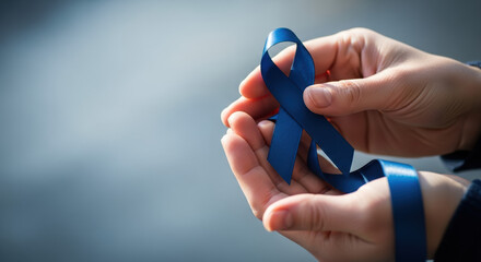 Holding blue ribbon in support of Blue November, awareness symbol. Blue November symbolizes support for men's health awareness campaign. Holding blue ribbon, supporting health and medicine,
