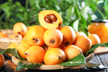 Fresh Loquat Fruits from Yunnan China on Wooden Plate with Cut Open Showing Seeds