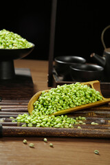 Fresh Green Mung Beans in Wooden Scoop on Bamboo Mat with Traditional Asian Kitchen Setup