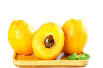 Fresh Loquat Fruits from Yunnan Panzhihua China on Wooden Tray with Mint Leaves