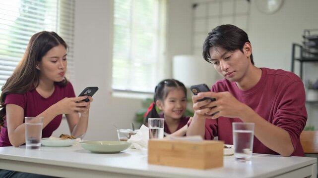Bored child feeling lonely during family dinner with addicted parents
