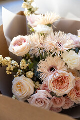 Mixed flower bouquet with roses, gerberas, and berries, carefully placed inside a cardboard delivery box, ready for gift giving