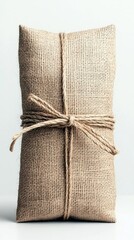A cylindrical object wrapped in textured burlap fabric and secured with natural twine, tied in a bow.