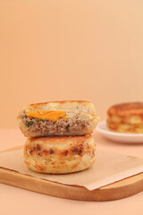 Gourmet Breakfast Sandwich with Fried Egg and Meat on Golden Buns Served on Wooden Board