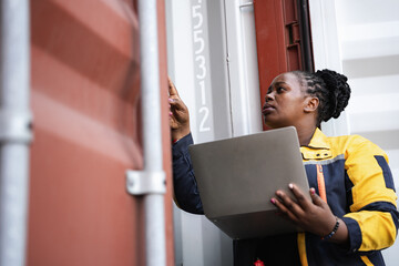 African woman logistics workers use notebook computer checking container