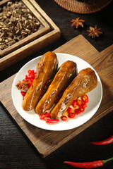 Spicy Marinated Duck Head Asian Delicacy with Chilies and Star Anise on Rustic Wooden Board