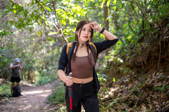 Woman hiking in forest pausing on trail