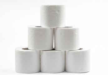 Stack of six white toilet paper rolls arranged in a pyramid on white background, product minimalism, hygiene, bathroom.